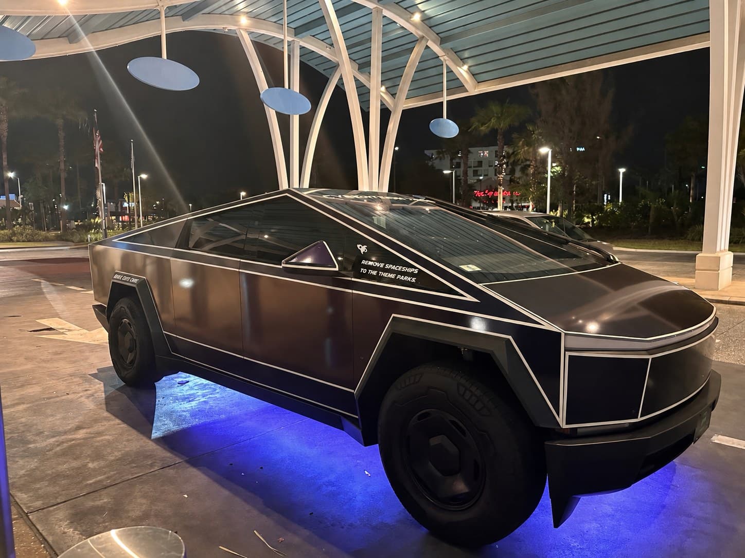 G-Force Ridez Cybertron 7000 — black pinstripe-wrapped Cybertruck with blue underglow at night