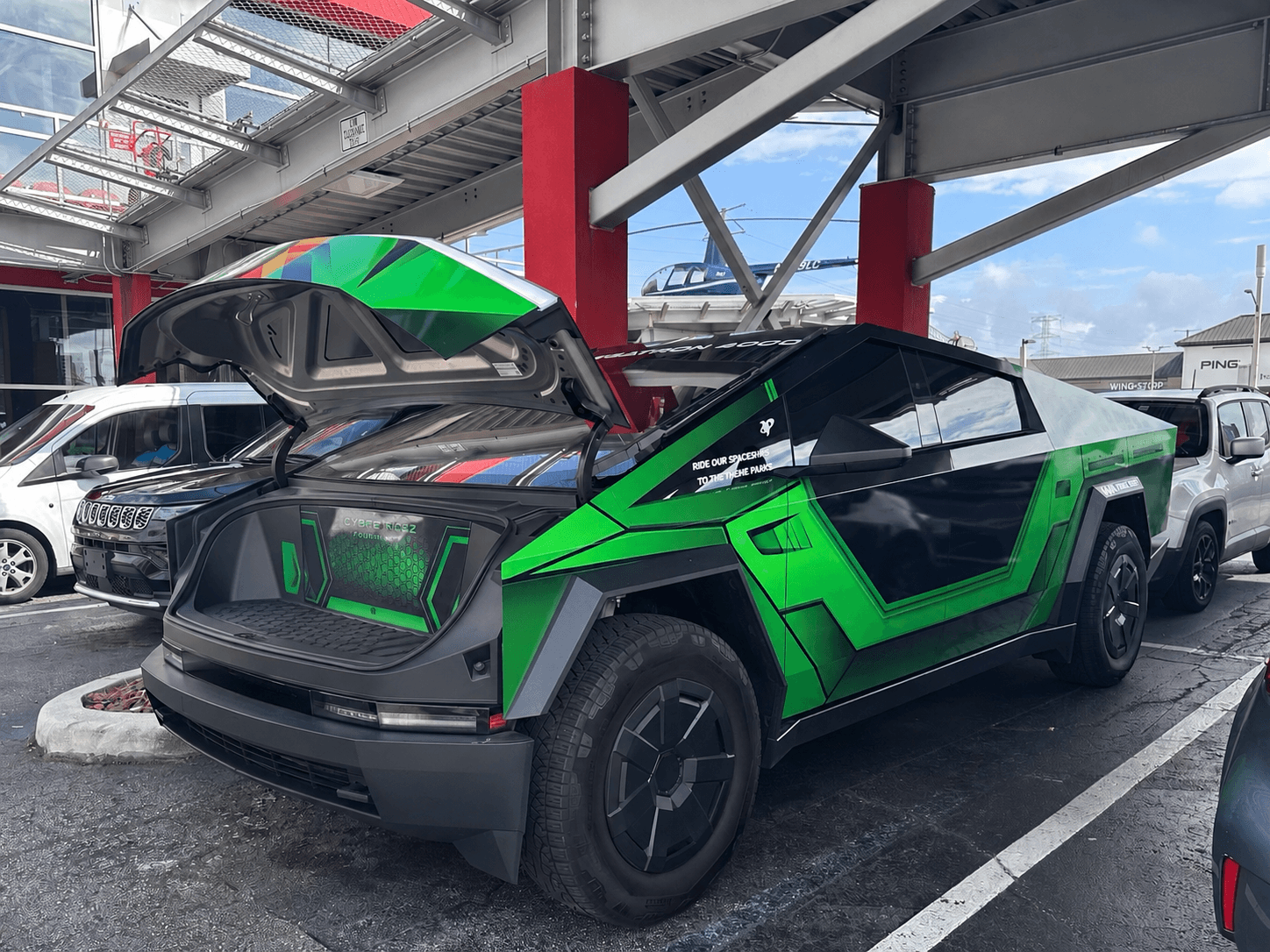 G-Force Ridez Megatron 4000 — green and black wrapped Cybertruck at airport